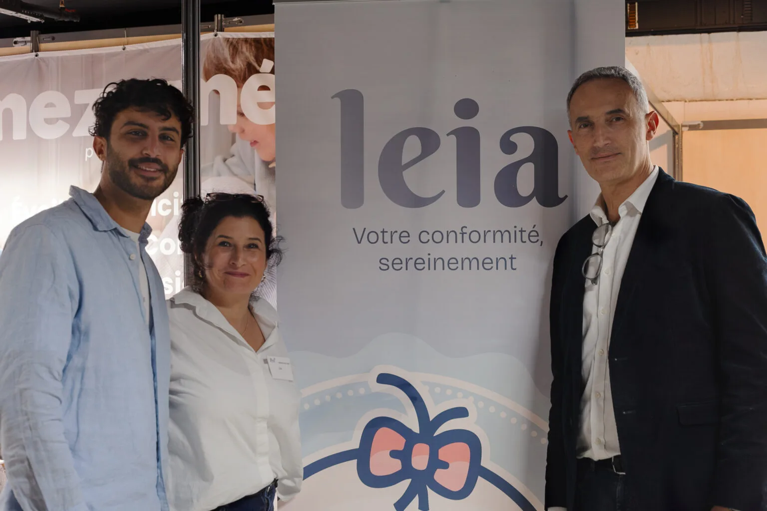 Romain Sessine et ses parents Aurélie et Tony devant le kakémono Leia sur un salon petite enfance