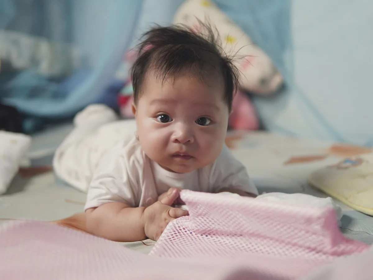 Bébé allongé sur le ventre dans son lit, accueilli en micro-crèche