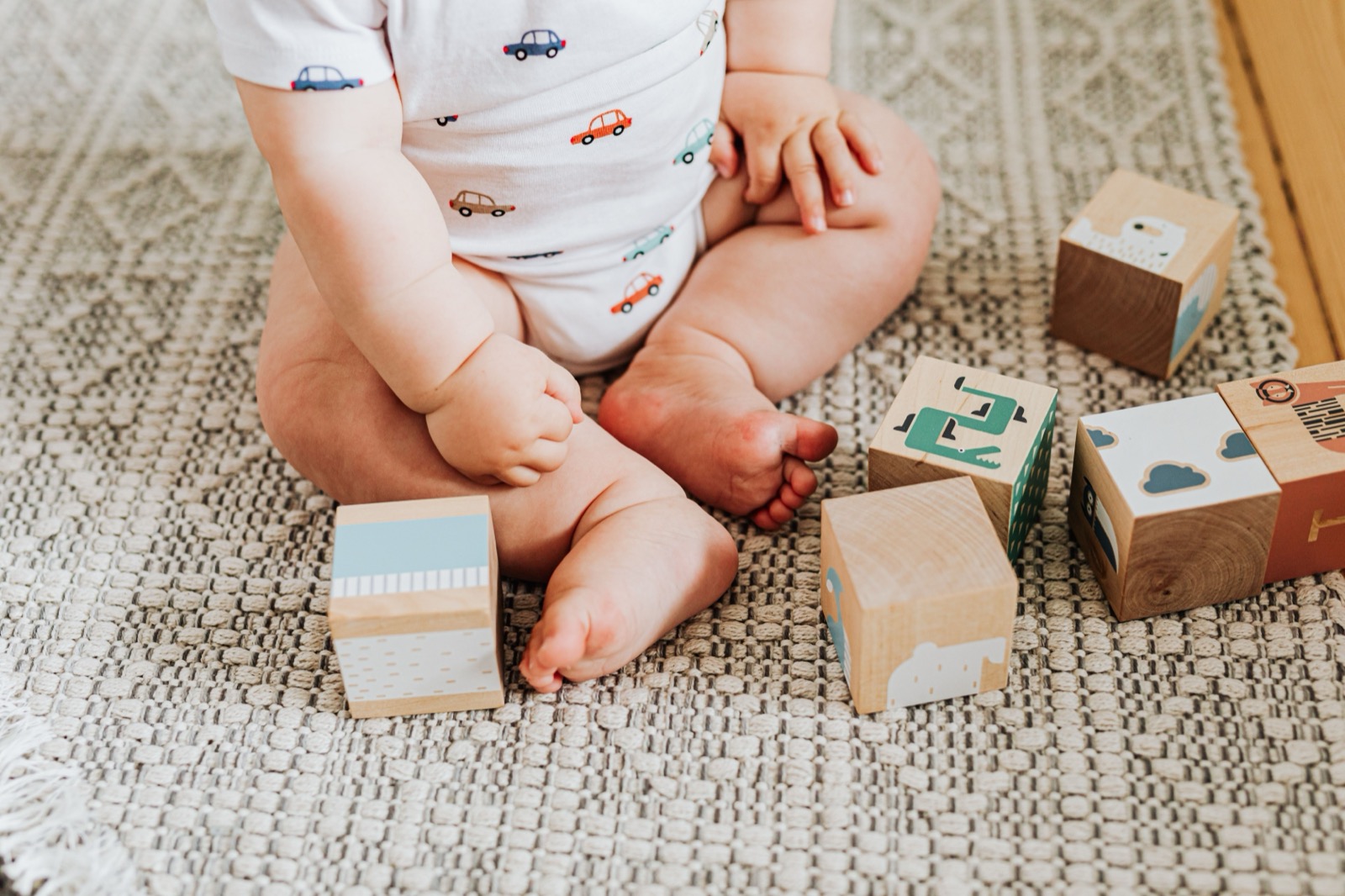 Jouets et cubes en bois posés au sol dans une section de crèche