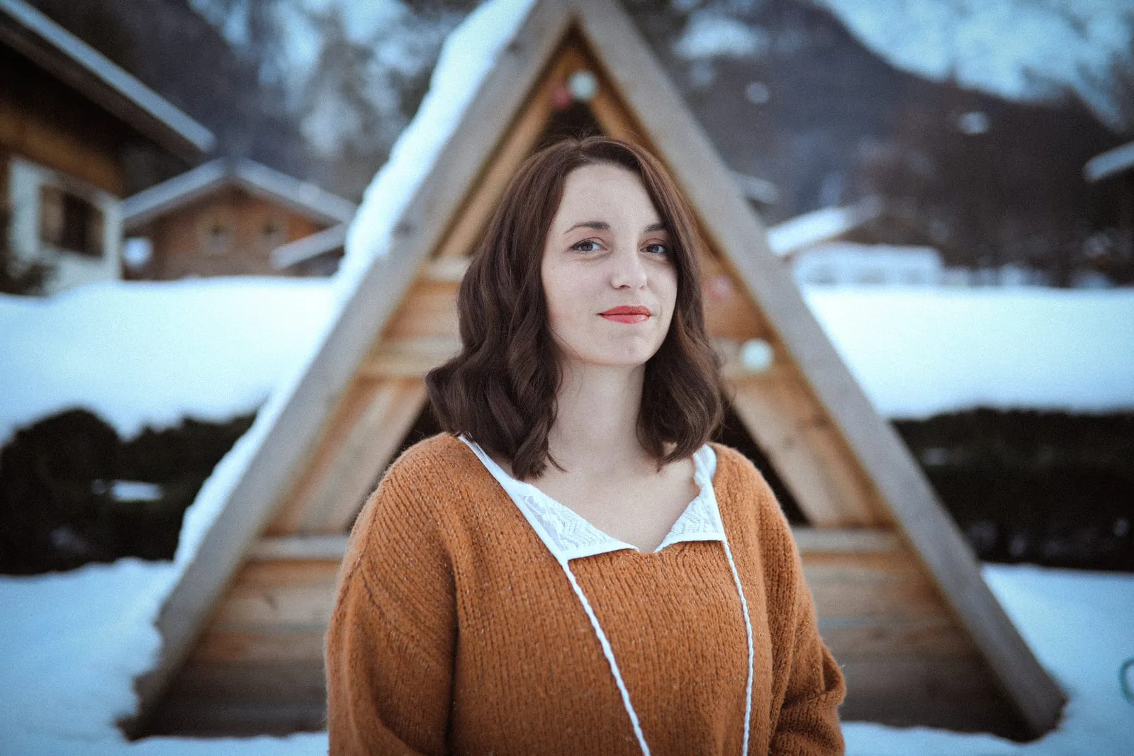 Charline Cachat devant une cabane en bois sous la neige